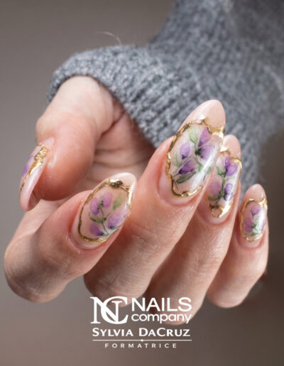 Nail art floral violet fait main avec détails dorés effet miroir par Sylvia Da Cruz, styliste ongulaire à Sancé.